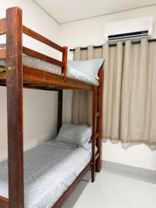 a bunk bed room with two bunk beds and a window at O mais charmoso do centro in Sinop