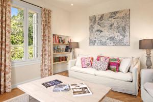 a living room with a white couch and a table at Villa du Claoux Superieur in Vence