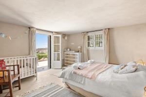 a bedroom with a bed and a crib and a window at Villa du Claoux Superieur in Vence +40 photos