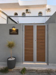 two wooden doors on the side of a building at Celivine Seaside Residence in Faliraki