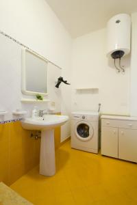 a bathroom with a sink and a washing machine at Appartamenti Elios in Birgi Vecchi
