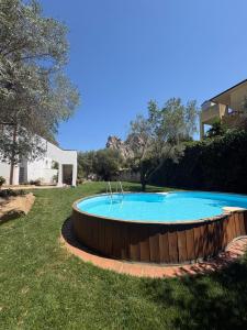 a large swimming pool in a yard with a wooden perimeter at Minnanni in San Pantaleo