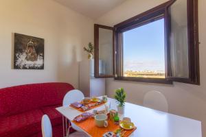 a living room with a red couch and a table at Appartamenti Elios in Birgi Vecchi