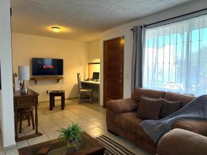 a living room with a couch and a desk at Casa Rincón Colonial, Confort y tranquilidad in San Miguel de Allende