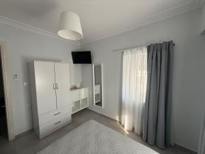 a room with a white cabinet and a window at Mpampis House in Ammouliani