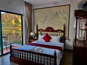 a bedroom with a bed and a large window at Mountainview tam coc villa in Vũ Lâm