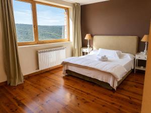 a bedroom with a bed and a large window at Winahost Gran Hotel Pandorado in Pandorado