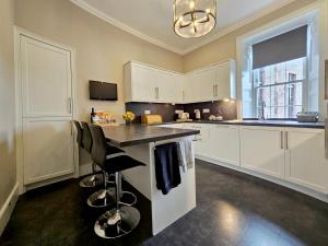 a kitchen with white cabinets and a counter top at No. 41 Town House in Inverness