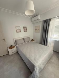 a bedroom with a large bed and a window at Mpampis House in Ammouliani +5 photos