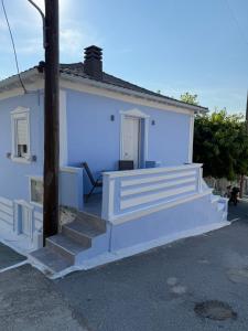 a white house with stairs in front of it at Mpampis House in Ammouliani