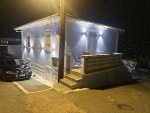 a blue house with a car parked in front of it at Mpampis House in Ammouliani