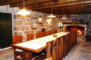 ein Esszimmer mit einem Tisch, Stühlen und einem Kamin in der Unterkunft Stone House Varoš in Starigrad-Paklenica