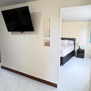 a bedroom with a bed and a flat screen tv on a wall at Comodo aparta estudio en Jerico Antioquia in Jericó