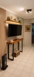 a living room with a flat screen tv on a table at Caelum House Familiar Con Cochera in Rafaela