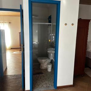 ein Badezimmer mit Toilette und einer blauen Tür in der Unterkunft Pousada Luz in Iriri + 70 Fotos