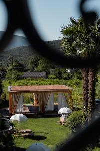a pavilion with chairs and umbrellas in a yard at Casa Prana in Tegna