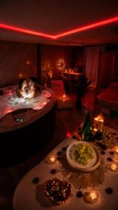 a room with two people in a tub with a plate of food at VIP Wellness apartma Immortality in Zgornja Velka
