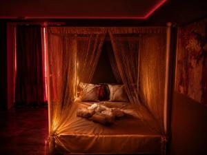 a bed with curtains and a teddy bear on it at VIP Wellness apartma Immortality in Zgornja Velka