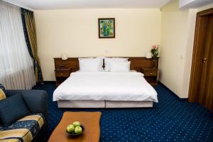 a hotel room with a bed and a couch at Park Hotel Sankt Peterburg in Plovdiv