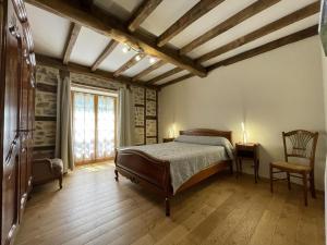 a bedroom with a bed and a chair and a window at Sagarra in Saint-Étienne-de-Baïgorry