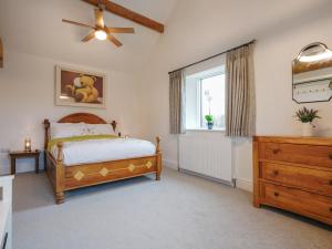 a bedroom with a bed and a window and a dresser at Westhills Courtyard - The Loft in Winster