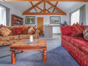 a living room with a red couch and a table at Westhills Courtyard - The Loft in Winster