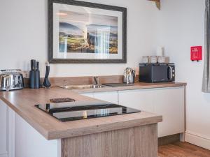 a kitchen counter with a sink and a microwave at Westhills Courtyard - The Loft in Winster