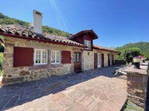 a stone house with red doors and a patio at Sagarra in Saint-Étienne-de-Baïgorry