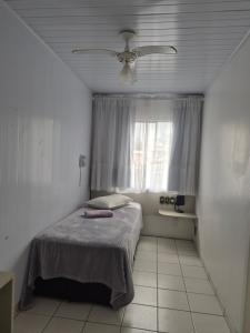 a bedroom with a bed and a ceiling fan at Hotel Eduardo's in Rio do Sul