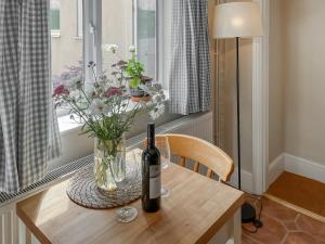 a table with a bottle of wine and flowers on it at The Cartshed - Uk50426 in Malton