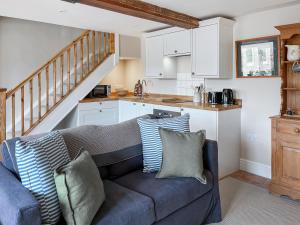 a living room with a couch and a kitchen at The Cartshed - Uk50426 in Malton