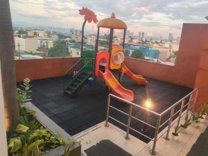 a playground with a slide on a balcony at Staycationbabe Gwen in Manila