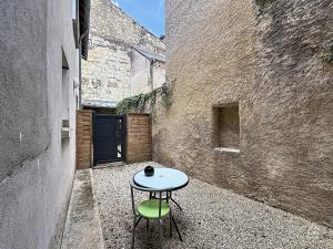 a small table and a green chair in an alley at Urban Grey - Terrasse - Wifi in Châtellerault