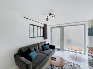 a living room with a couch and a table at Urban Grey - Terrasse - Wifi in Châtellerault