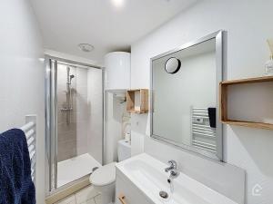 a white bathroom with a sink and a mirror at Urban Grey - Terrasse - Wifi in Châtellerault +12 photos