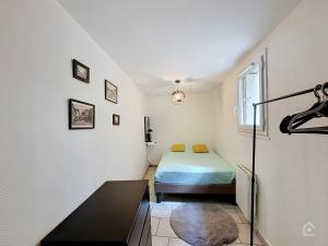 a small room with a bed and a window at Urban Grey - Terrasse - Wifi in Châtellerault
