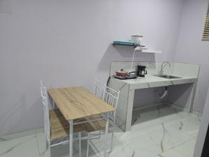 a small kitchen with a sink and a table and chairs at Apartment Torres in Manuel Antonio +4 photos