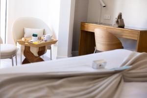 a bedroom with a bed and a desk and a chair at Cristal Hôtel & Spa in Cannes