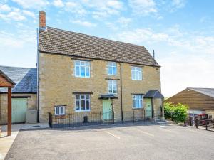 a brick house with a gate in a parking lot at Greenhill Farmhouse in Bletchingdon