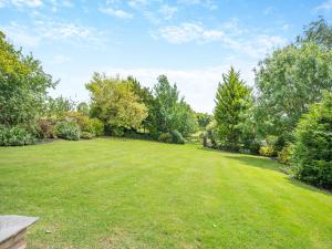 a large yard with green grass and trees at Greenhill Farmhouse in Bletchingdon