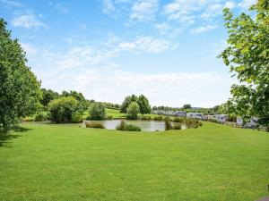 a grassy field with a river in the distance at Greenhill Farmhouse in Bletchingdon +23 photos