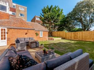 a patio with couches and a table in a yard at West Bay House in Westgate-on-Sea