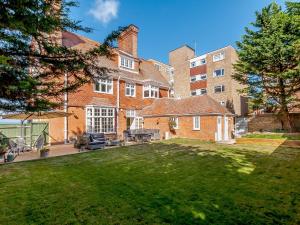 an exterior view of a large brick building with a yard at West Bay House in Westgate-on-Sea