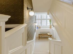 a hallway with white doors and a window at West Bay House in Westgate-on-Sea