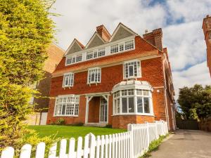a large red brick house with a white fence at West Bay House in Westgate-on-Sea +57 photos