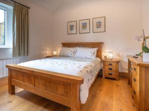a bedroom with a large wooden bed and two night stands at The Cottage - Ukc9711 in Winster