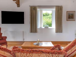 a living room with a couch and a table and a window at The Cottage - Ukc9711 in Winster