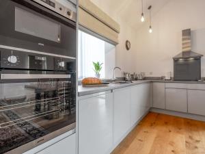 a kitchen with white cabinets and a large window at The Cottage - Ukc9711 in Winster +14 photos