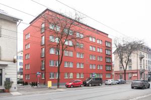 un edificio rojo con coches estacionados frente a él en CITY STAY - Kieselgasse en Zúrich