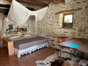 a bedroom with a bed and a table and a window at Eco-immersion in Limogne-en-Quercy +21 photos